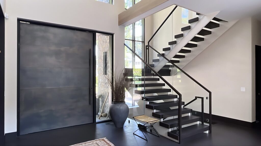 Modern entry in Wilton, CT with a floating staircase, dark floor finish, and a clean custom interior painting palette