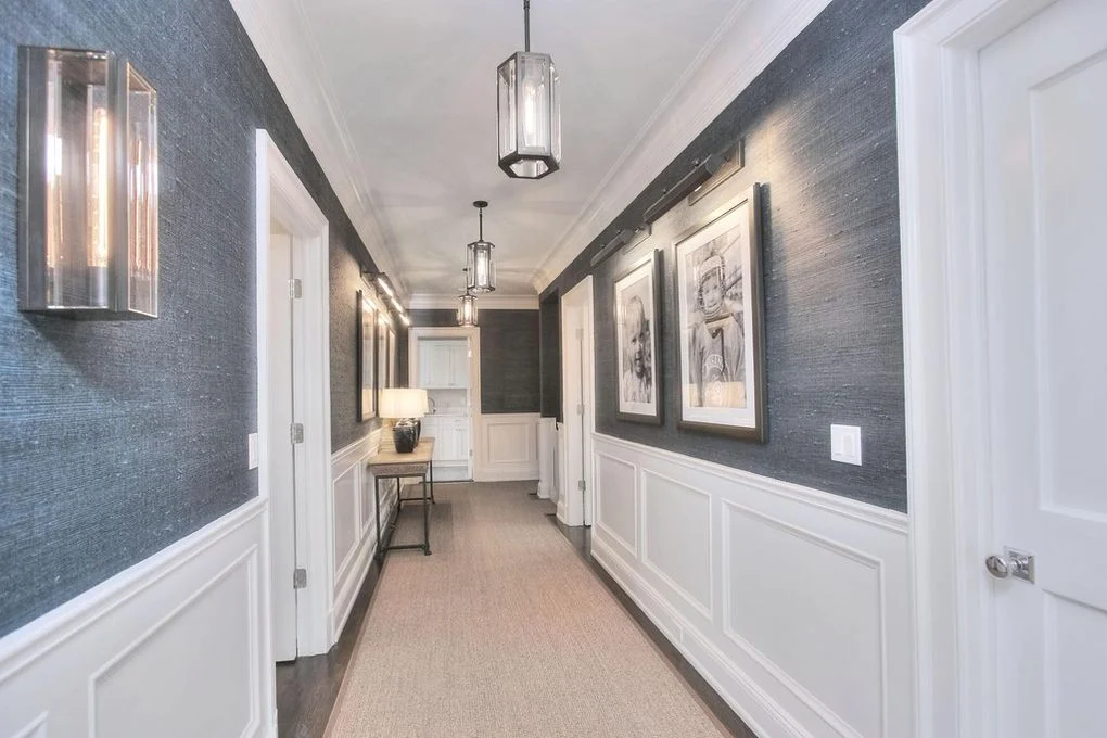 Dark hallway wallpaper in New Canaan, CT with white wainscoting, crisp trim lines, and a refined custom finish