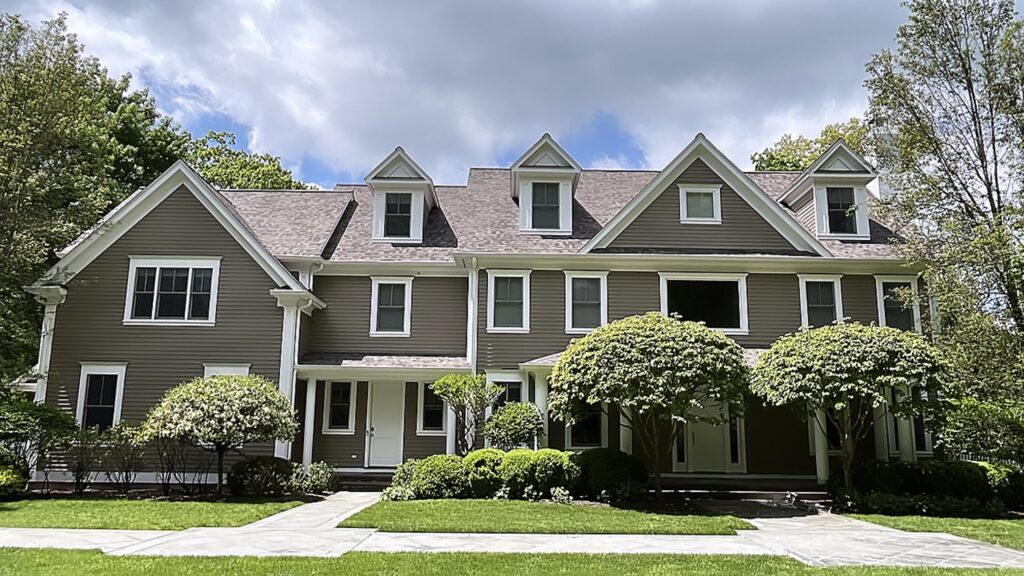 Taupe siding home in Westport, CT with white trim, refreshed exterior paint, and a clean front elevation framed by mature landscaping