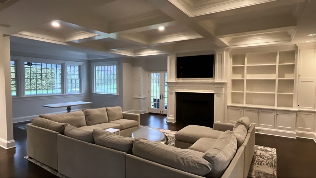Coffered living room in Darien, CT with white built-ins, a fireplace wall, and a clean neutral interior painting finish
