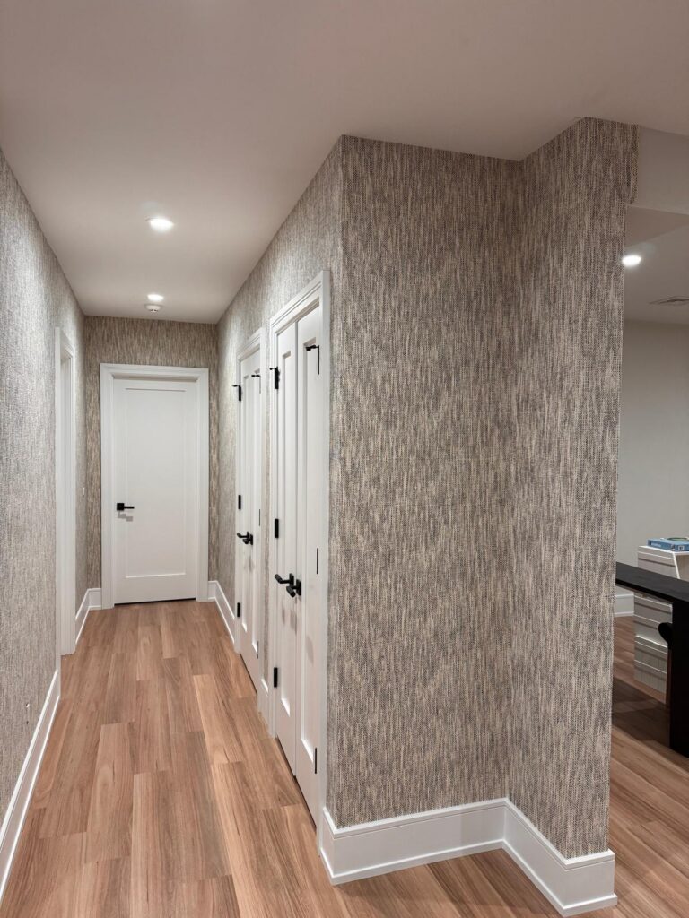 Textured hallway wallpaper in South Salem, NY with crisp white trim, clean corner lines, and a refined custom finish