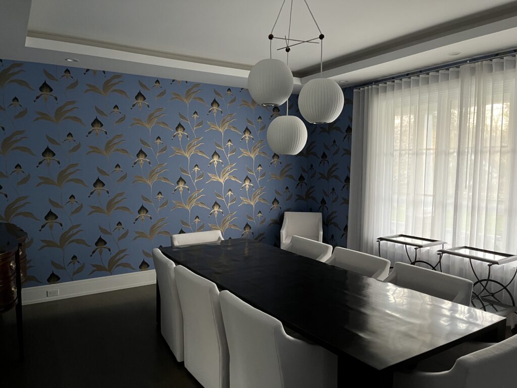Designer accent wall in Westport, CT with blue wallpaper, botanical pattern, and a dramatic formal dining room setting